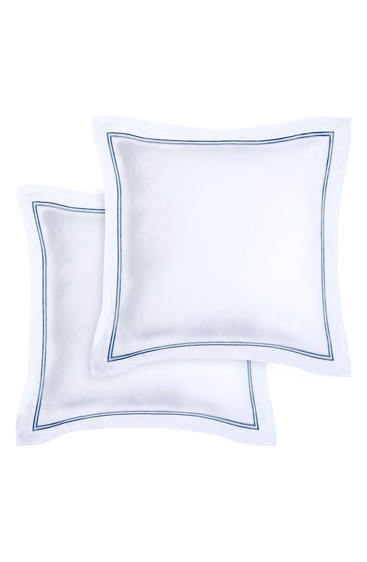 two white pillows with blue trims on them