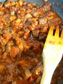 a wooden spoon in a pot filled with stew