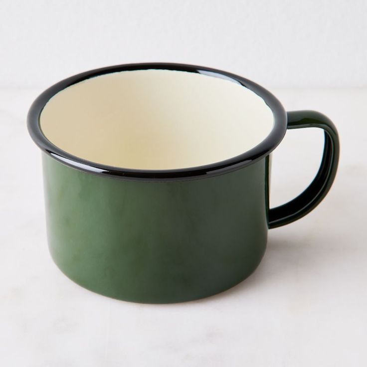 a green and white cup sitting on top of a table