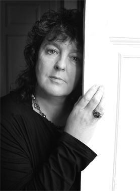 a black and white photo of a woman leaning against a door