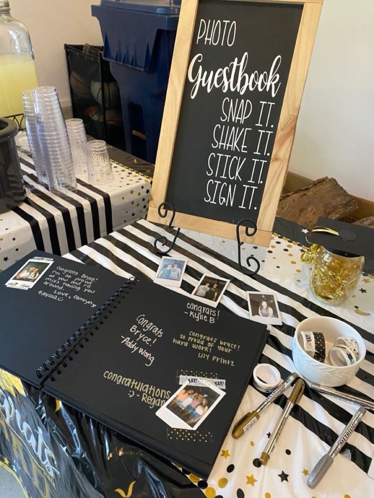 a table topped with lots of black and white items next to a chalkboard sign