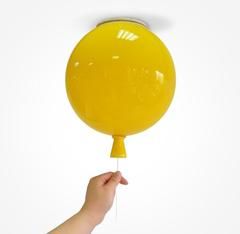 a hand holding a yellow balloon in the air