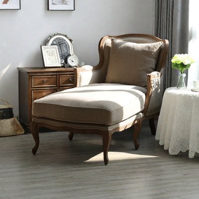 a chair sitting in front of a window next to a dresser