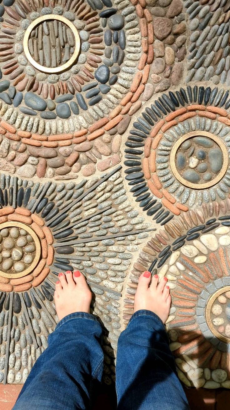 a person standing on top of a stone floor next to a circular design in the ground