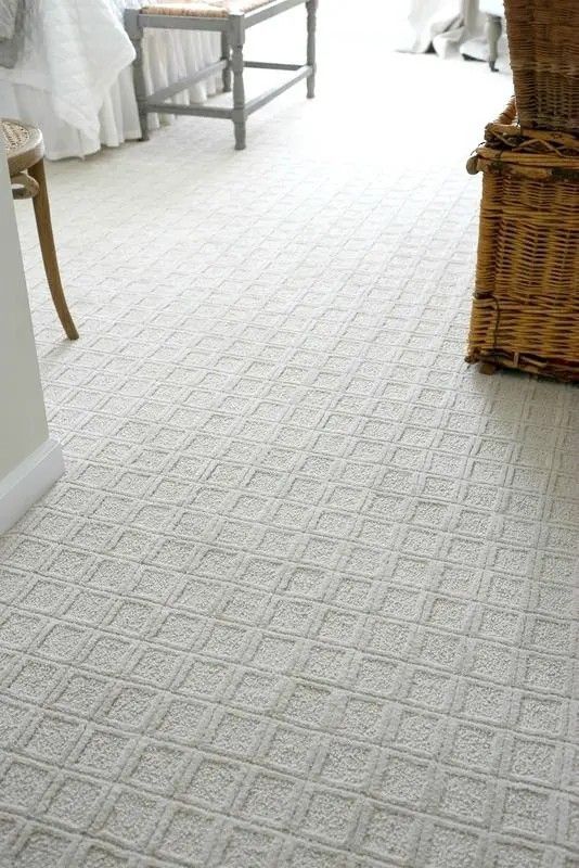 a bedroom with white carpet and wicker baskets on the floor, along with a bed