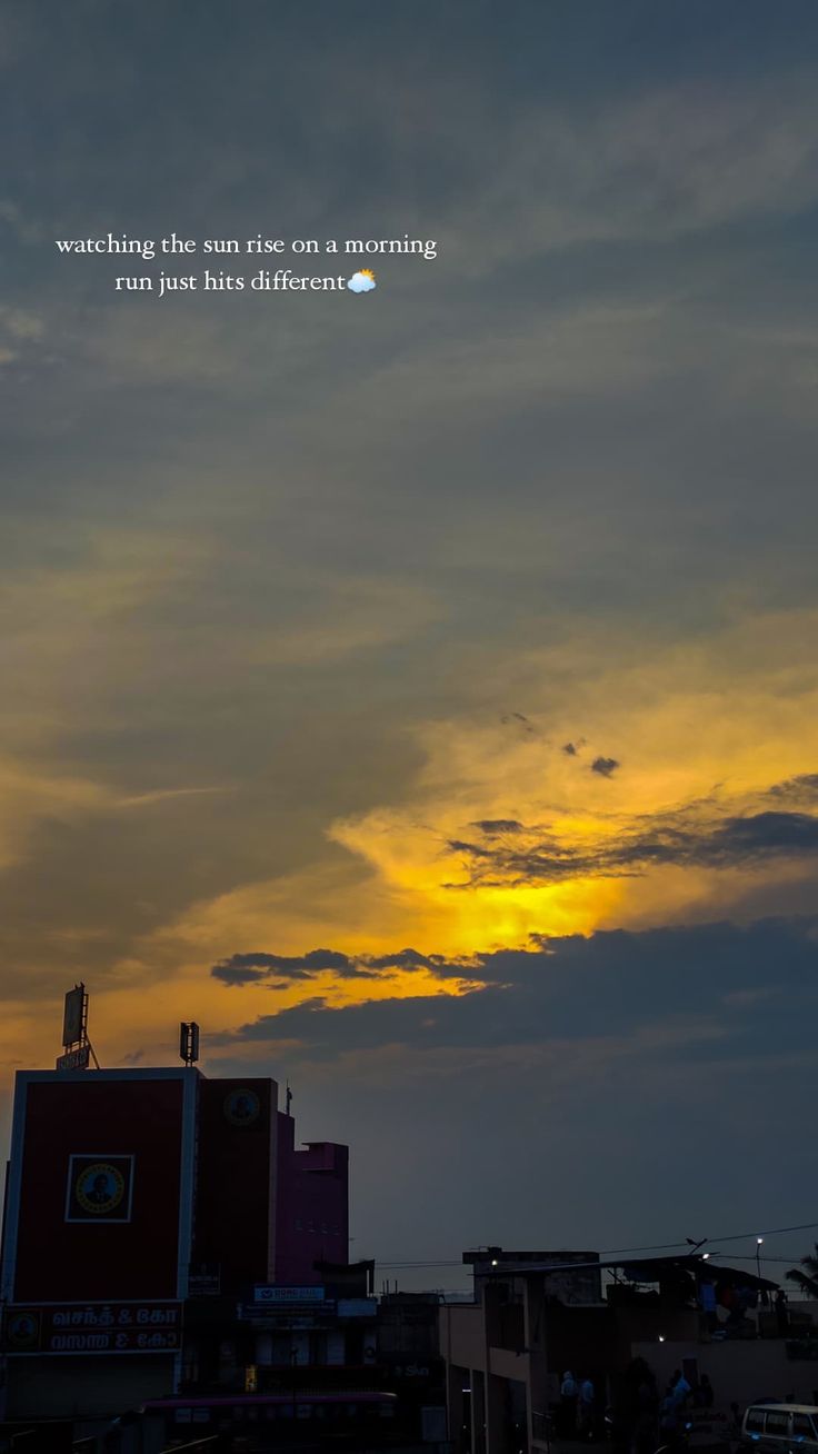 the sun is setting behind some buildings and clouds in the sky with a quote written on it