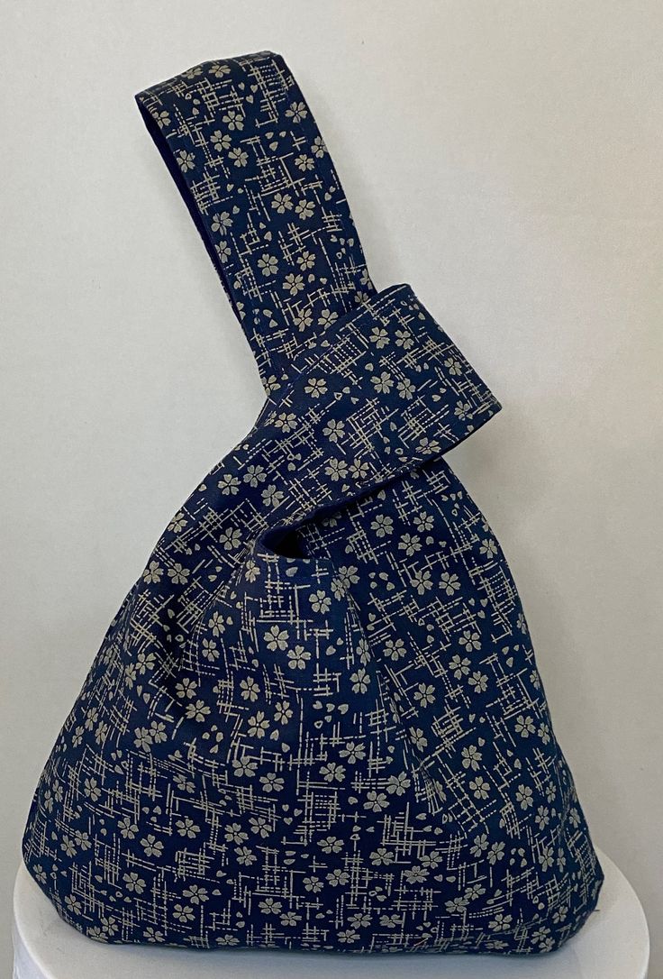 a blue and white patterned bag sitting on top of a table next to a wall