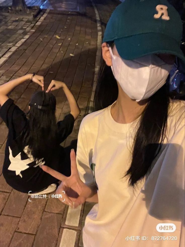 two girls wearing face masks on the street