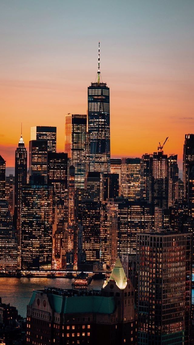 the city skyline is lit up at night, with skyscrapers in the foreground