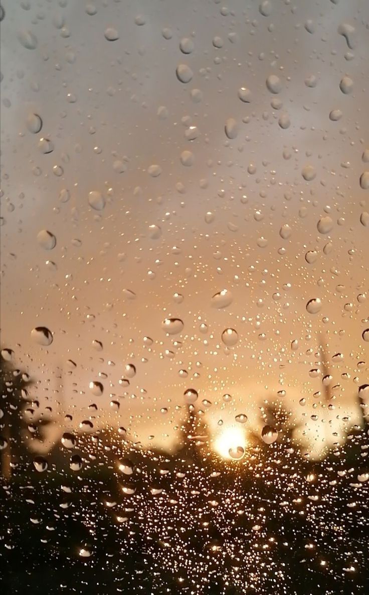 the sun is shining through raindrops on a window