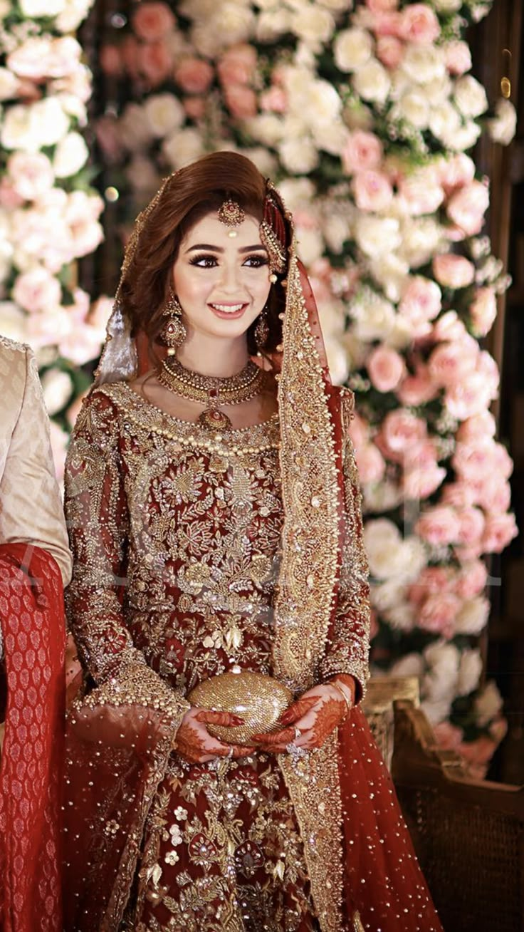 a bride and groom posing for a photo in front of flowers at their wedding ceremony