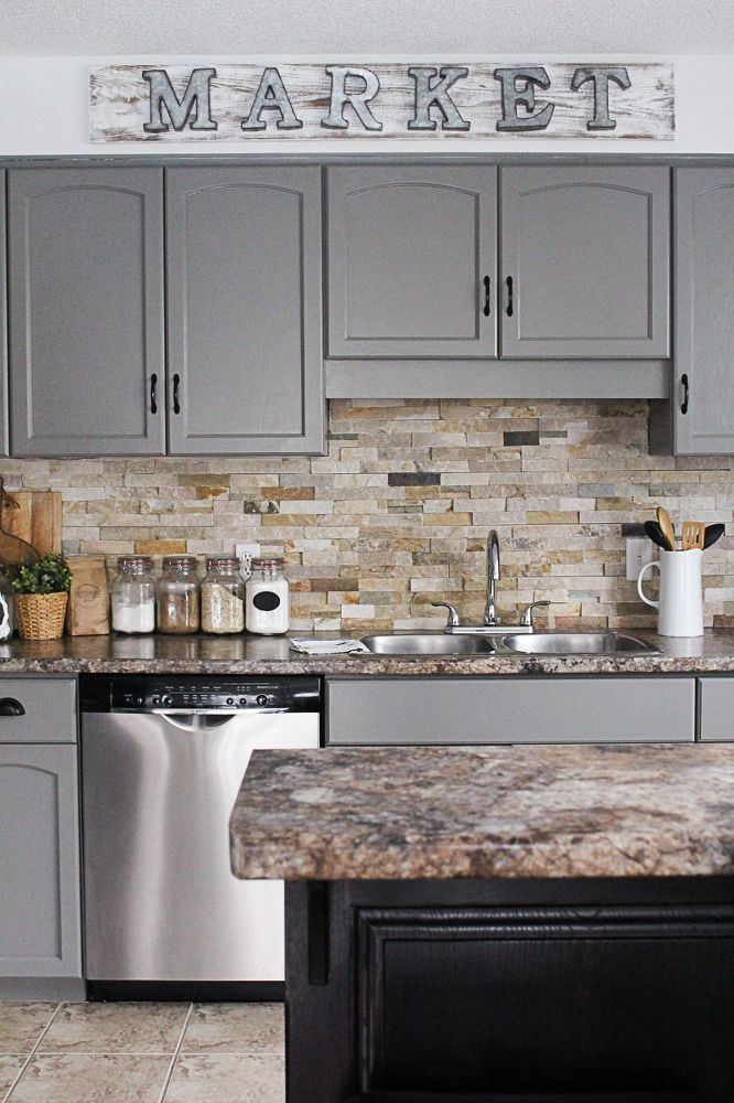 a kitchen with gray cabinets and marble counter tops is featured on the home depot website