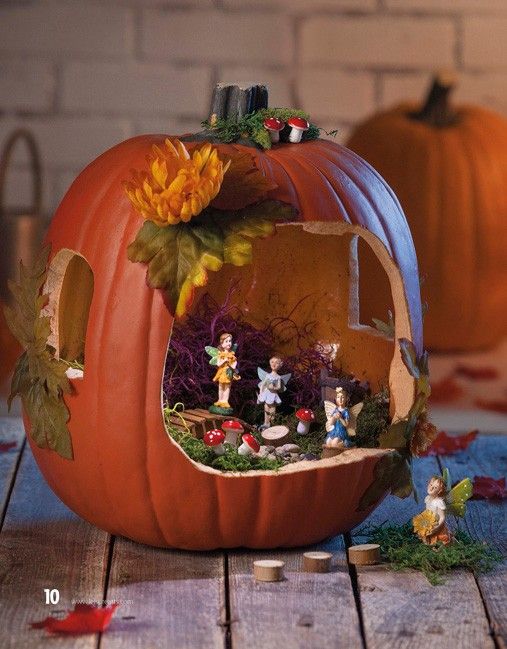 a pumpkin shaped like a house with figurines inside