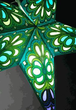 a green and blue star shaped decoration hanging from a ceiling fixture in the shape of a flower