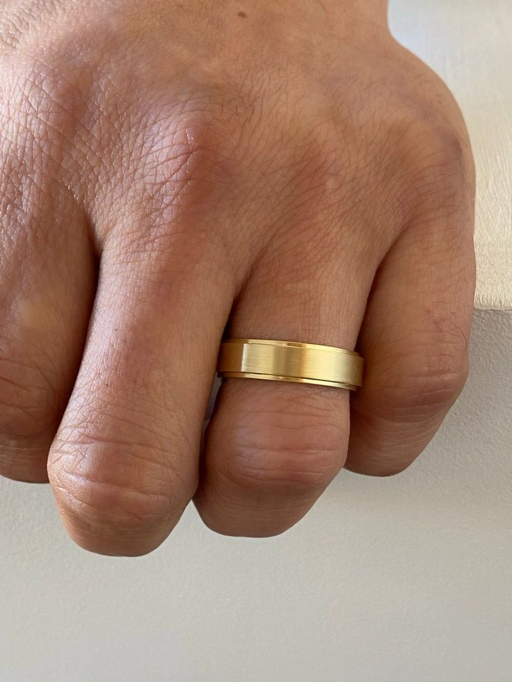 a man's hand with a gold ring on it