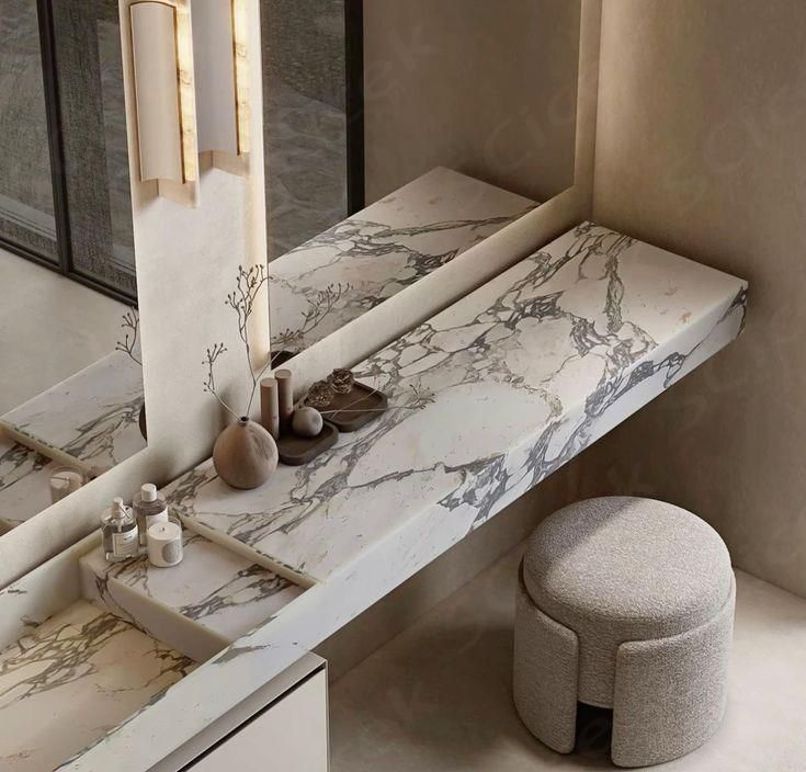 a bathroom with marble counter top and stool