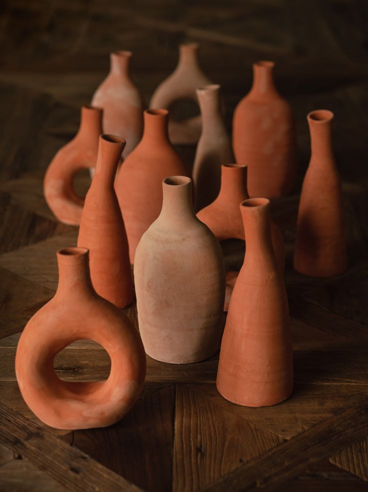 a group of clay vases sitting on top of a wooden table