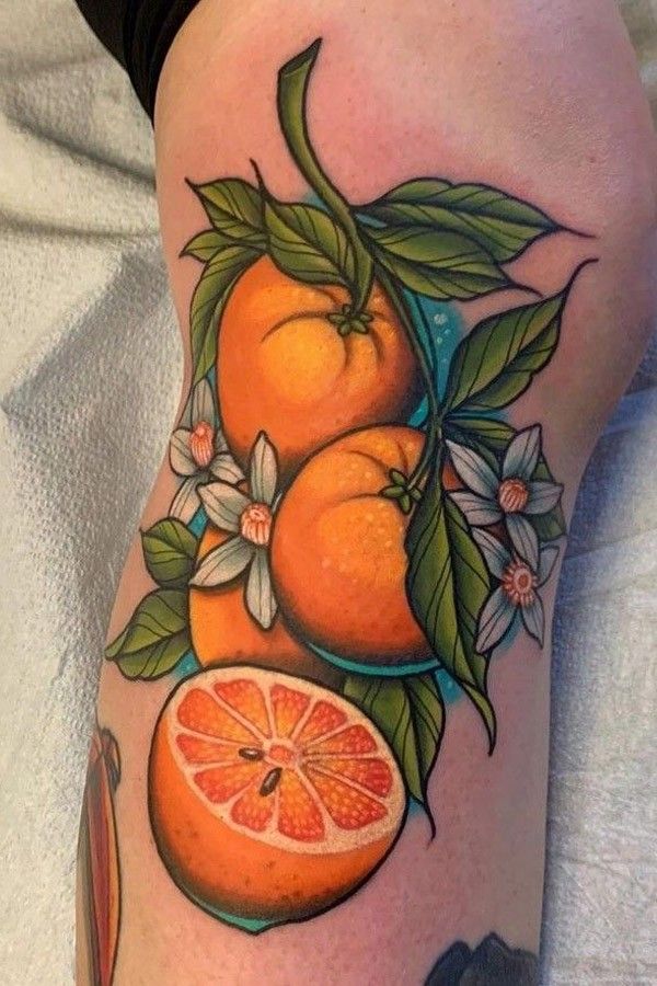 an orange with leaves and flowers on the thigh