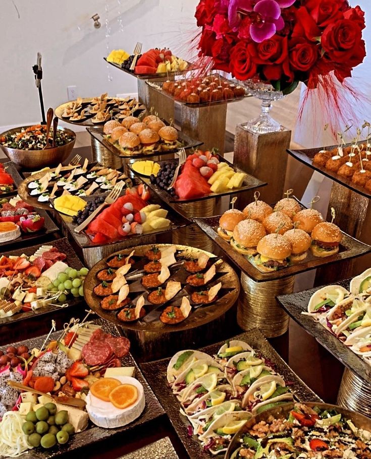 a table topped with lots of trays filled with different types of foods and desserts