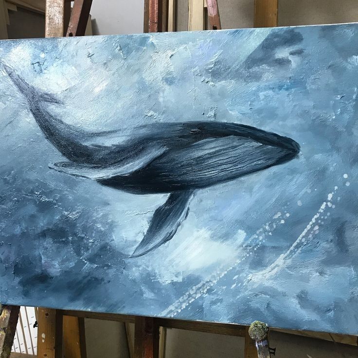 a painting of a whale is being displayed in an art studio with easel and paintbrushes