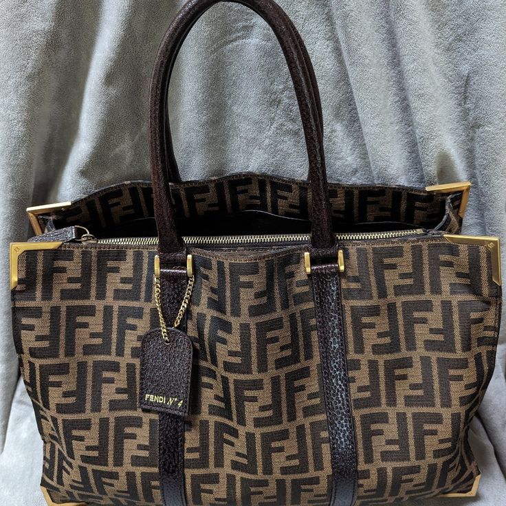 This Fendi Tote Stands Out With It's Zucca Pattern And Is Very Versatile. It's Straight Forward Design Lends Itself To A Very Functional Bag. Bag Measures 15 X 10 X 5. Normal Wear On The Handles As Shown. The Interior Has A Center Pocket And Two On The Side Panel. Fendi Tote, Straight Forward, Bag Bag, Fendi Bags, Panel Siding, Womens Tote Bags, Fendi, Handles, Canvas