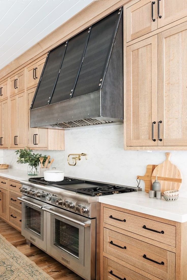 a kitchen with wooden cabinets and stainless steel stove top oven, dishwasher, and range hood