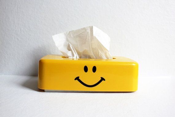 a tissue dispenser with a smiley face on it