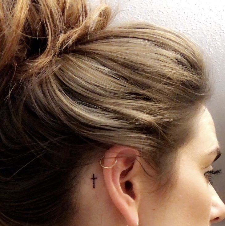 a woman with a cross tattoo on her left ear