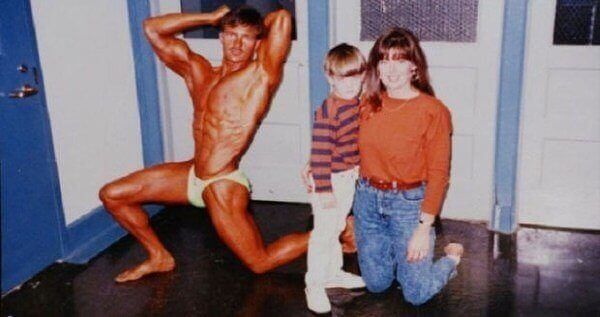 an old photo of a man and two children posing for a picture in front of a door