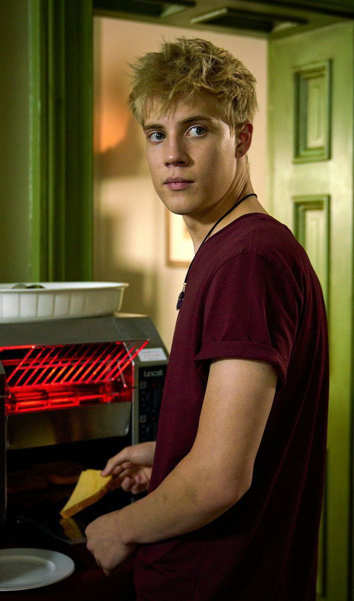 a young man standing in front of an open oven