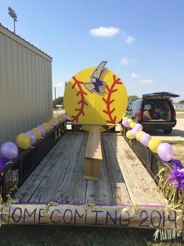 a big yellow ball sitting on the back of a truck with balloons and streamers