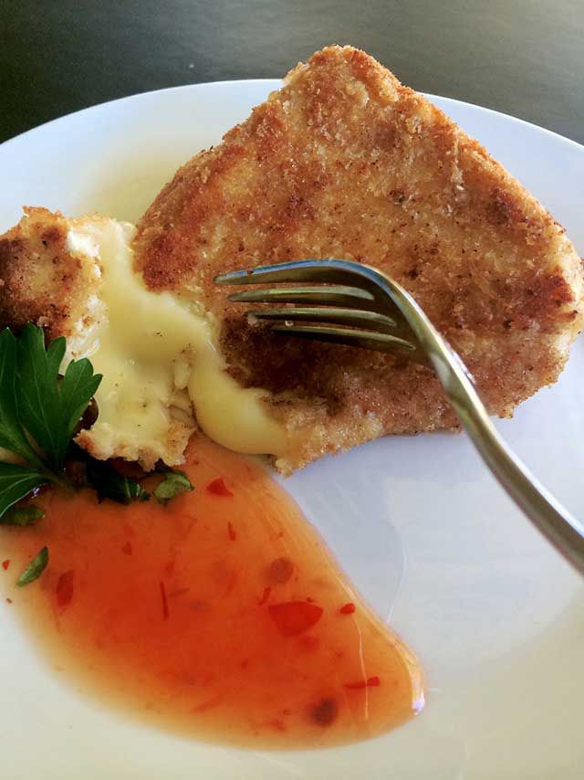 a piece of bread on a plate with sauce and a fork