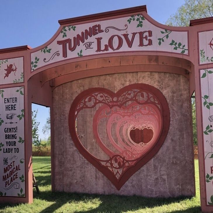 the tunnel of love sign is painted pink and red