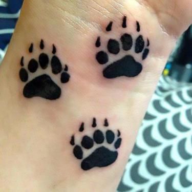 two small black and white paw prints on the wrist