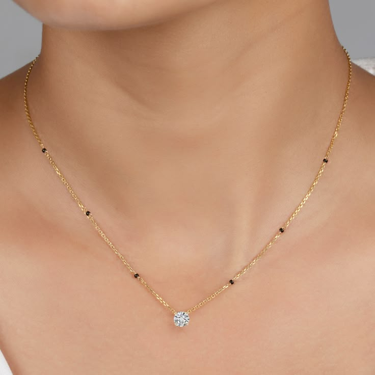 Step into elegance with the Roshni Mangalsutra, a perfect blend of timeless tradition and modern sophistication. This stunning piece showcases a brilliant round, certified lab-grown diamond, available in various sizes and grades to suit your style. The diamond is beautifully set in a classic fixed pendant, ensuring it captures light with every movement. The 4-pronged setting provides both security and a striking presentation, making the diamond the focal point of this luxurious piece. Crafted wi Simple Modern Mangalsutra, Luxury Traditional Mangalsutra For Festivals, Diamond Chain Pendant, Luxury 22k Gold Mangalsutra, Wedding Mangalsutra Designs, Mangalsutra Designs Diamond Modern, Refined Solitaire Necklace With Diamond Accents For Wedding, Refined Round Single Cut Diamond Necklace, Refined Wedding Diamond Necklace With Single Cut Diamonds