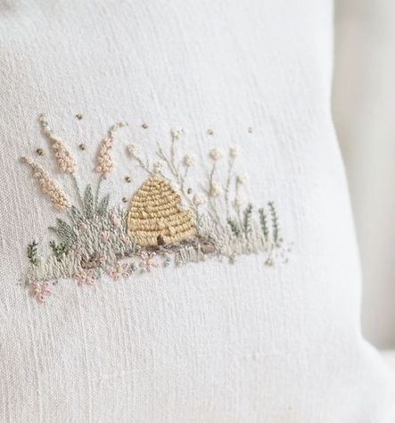 a close up of a white pillow with embroidered designs on the front and back of it