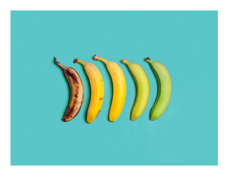 five bananas lined up in a row on a blue background