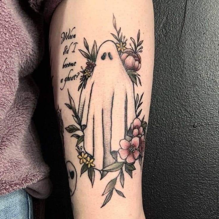 a woman with a tattoo on her arm has a white bird and flowers around it