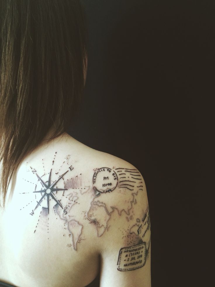 the back of a woman's shoulder with a map and compass tattoo on it