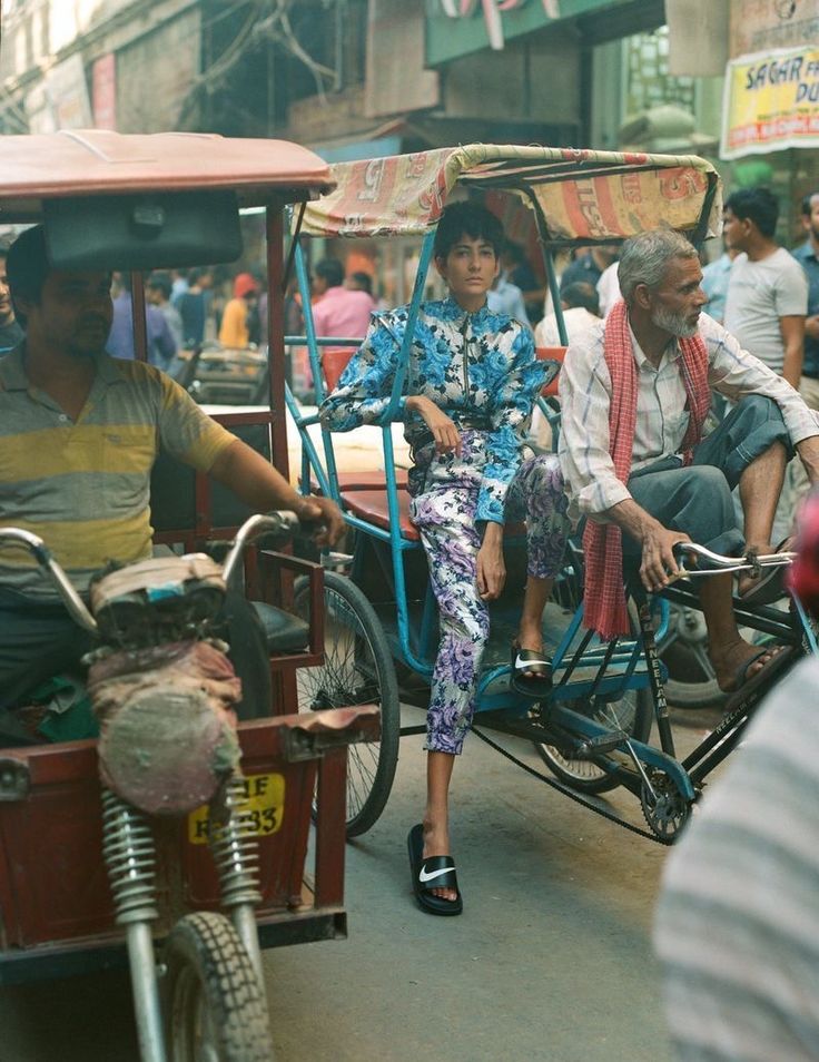 an old man and woman are riding in a rickshaw pulled by two people on the street