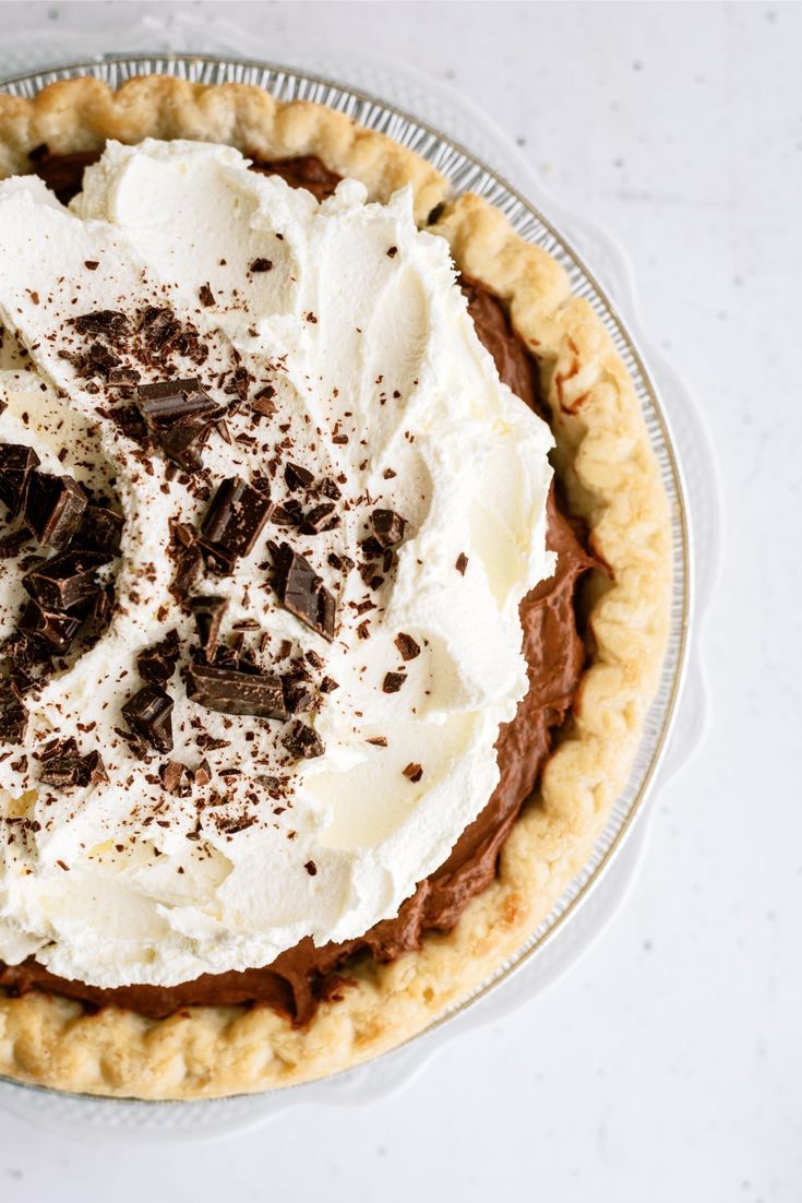 a pie with chocolate and whipped cream on top