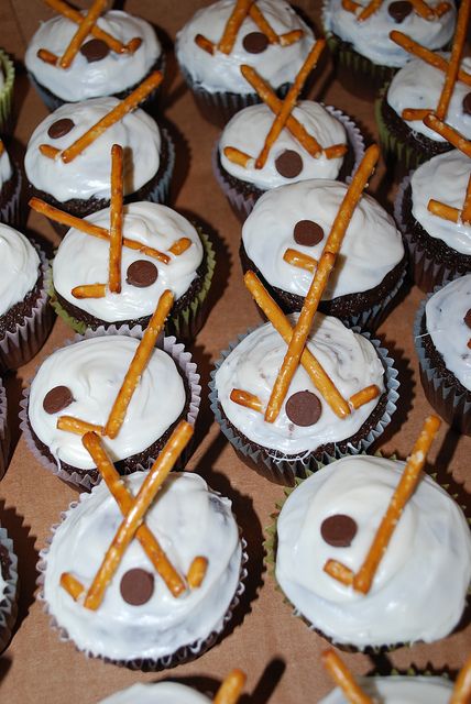 many cupcakes with white frosting and chocolate sticks sticking out of the top