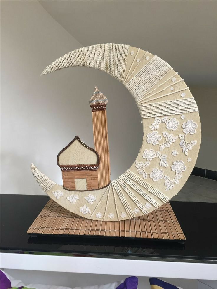 an intricately designed paper sculpture with a mosque in the middle on top of a black table