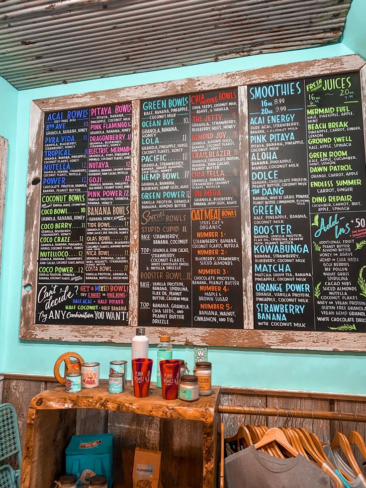 the menus on the wall are written in different colors and sizes, along with drinks