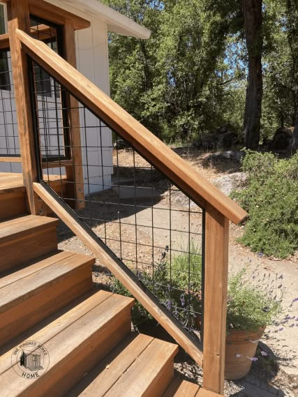 wooden steps leading up to a house with metal handrails and gated railing