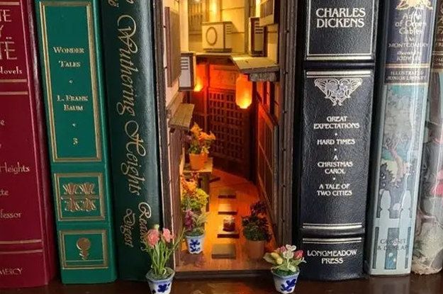 there are many books on the shelf with flowers in vases next to each other