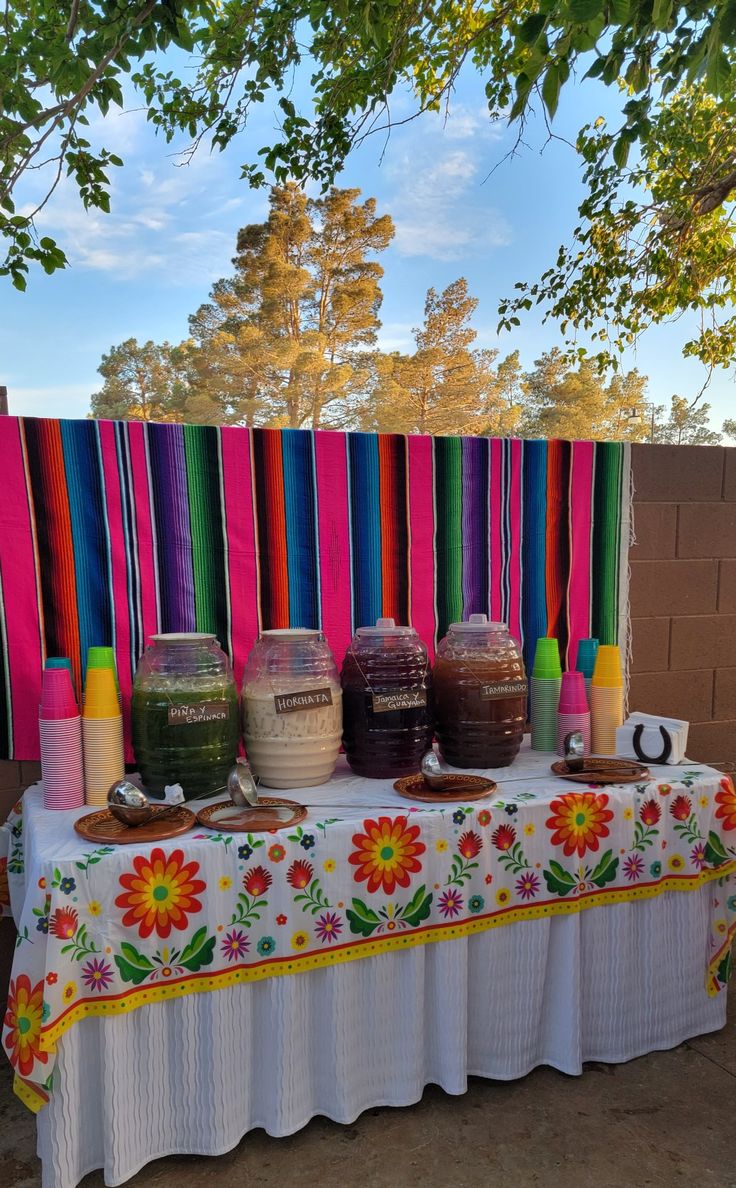 a table topped with lots of different types of condiments on top of a white table cloth