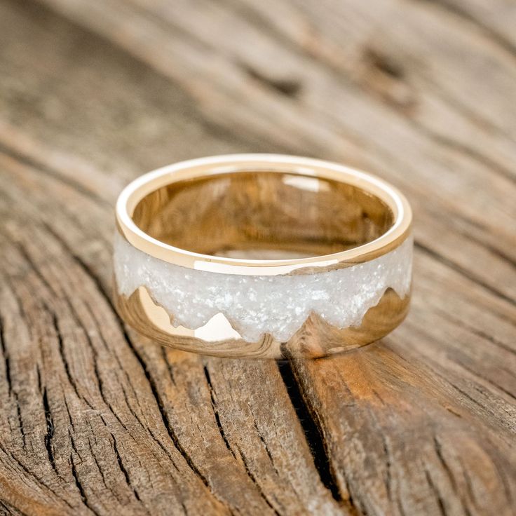 a close up of a wedding ring on a wooden surface