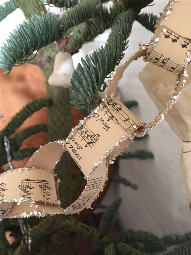 an ornament made out of sheet music is hanging from a christmas tree branch