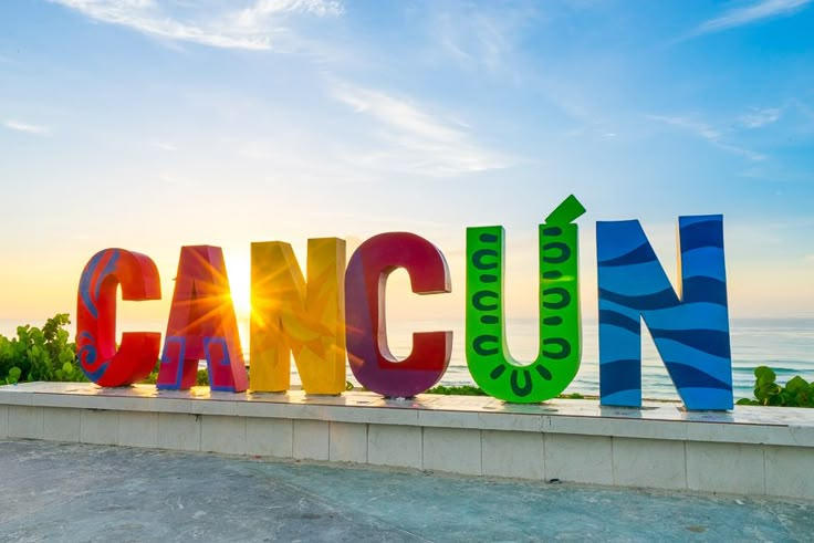 the word cancun spelled out in multicolored letters on top of a concrete wall